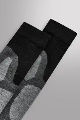 Calcetines deportivos largos de punto elástico, con diseño técnico y refuerzos en zonas de mayor fricción como puntera, talón y planta del pie. Presentan un patrón de bloques en tonos negros y grises.