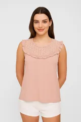 Musculosa de rayón color rosado, con cuello redondo y detalle de pechera en broderie con volados en los hombros.