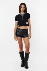 Remera corta negra de algodón tipo baby tee, con mangas cortas y detalles en blanco en cuello y mangas. Estampa frontal con la leyenda "Rocking Slaying" en blanco.