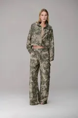 Chaqueta de sarja con corte cuadrado y silueta estructurada, con estampado de camuflaje en tonos verdes y tierra. Presenta cuello clásico, cierre frontal con botones metálicos y bolsillos frontales con solapa.