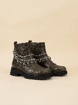 Botas cortas de cuero marrón con acabado texturizado, cierre lateral y suela track negra. Presentan un detalle decorativo de tres cadenas metálicas plateadas removibles alrededor del tobillo.