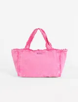 Bolso tipo tote de algodón con efecto lavado, diseño con bordes desflecados y asas fijas. Presenta un pequeño bordado decorativo en la parte frontal.
