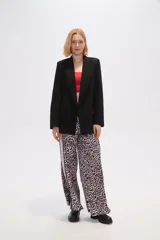 Blazer color beige de lino, con cuello solapa, corte holgado y bolsillos laterales.