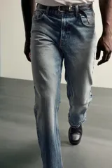 Jeans flare fit de denim de algodón en color celeste con lavado efecto desgastado. Presentan diseño de cinco bolsillos, tiro medio, cierre frontal con cremallera y botón, y bajo con acabado irregular.