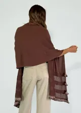 Chal de punto color beige con textura calada y volados en los bordes.