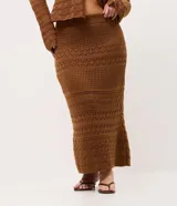 Pollera midi de tricot marrón con puntos calados y diseños geométricos, de corte levemente ajustado y cintura con pretina acanalada.