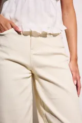 Jean de mujer color crema o blanco roto, de corte baggy y tiro medio. Confeccionado en algodón con un pequeño porcentaje de elastano.