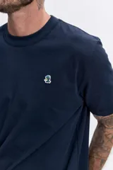 Remera de algodón color azul marino, de corte clásico y cuello redondo, con un pequeño logo bordado en el pecho.