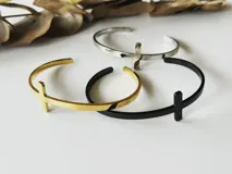 Brazalete rígido abierto de acero quirúrgico color negro con dije de cruz.