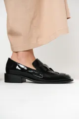 Mocasín de cuero charol negro con diseño enrejillado en la capellada y horma cuadrada.