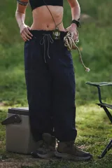 Pantalón de senderismo color azul marino oscuro, de corte relajado y tiro alto con cordón ajustable. Presenta costuras contrastantes claras y bolsillos cargo en los laterales.