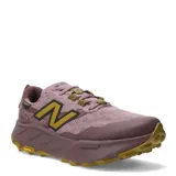 Championes de trail running New Balance Fresh Foam X Hierro, color rosado con logo 'N' en amarillo mostaza y suela dentada de goma.