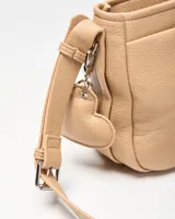 Bandolera beige de símil cuero con correa regulable y bolsillo frontal con broche a presión. Cuenta con aplique metálico con el logo de la marca en la parte inferior.