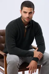 Buzo tejido de punto grueso con textura en relieve, cuello alto con cierre frontal parcial y detalles en gamuza en la solapa del cierre. Presenta puños y ruedo acanalados.