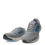 Championes de running New Balance Evoz Fresh Foam para hombre, color gris con detalles en azul y suela amortiguada.