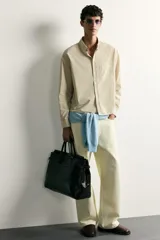 Jeans straight fit color beige claro, con tiro medio, pernera recta de cinco bolsillos y cierre frontal con cremallera y botón.