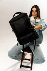 Mochila negra con múltiples bolsillos con cierre y manija superior.