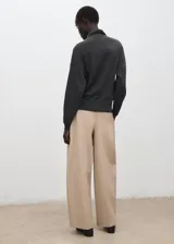 Jersey gris oscuro de cuello alto y manga larga, con diseño de punto suave y corte recto.