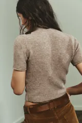 Jersey de punto de tacto suave, color gris jaspeado, con cuello subido y manga corta.