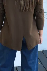 Sweater de punto color chocolate, con cuello redondo, manga larga y puños acanalados. Presenta un corte holgado con ruedo asimétrico.