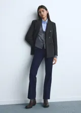 Jeans de tiro medio con corte flare y diseño crop. Presentan cinco bolsillos, cierre de cremallera con botón, trabillas en la cintura y bajo deshilachado.