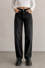 Jean wide leg de tiro alto en color negro gastado, con diseño clásico de cinco bolsillos y cierre frontal con botón y cremallera.