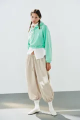 Pantalón de tiro medio y cintura elástica con cordón de ajuste, bolsillos laterales y bajo abullonado con puños elásticos. Confeccionado en poliamida.