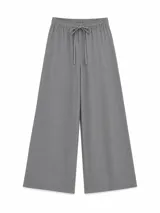 Pantalón gris de corte holgado y perneras anchas, con cintura elástica fruncida y cordón ajustable delantero.