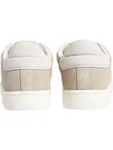 Zapatillas bajas de cuero color beige con logo CK bordado en el lateral y suela blanca con el nombre de la marca.