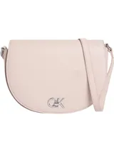 Cartera cruzada Calvin Klein de color rosa pálido, con forma de media luna o silla de montar. Presenta un logo metálico plateado con las iniciales 'CK' en el frente. La correa es ajustable y delgada.