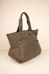 Bolso tipo shopper color beige, con asas fijas superiores y correa desmontable y regulable. Cuenta con dos bolsillos externos y tres bolsillos internos.