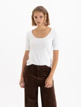 Remera de poliamida con elastano, color blanco, con escote redondo amplio y mangas cortas al codo.