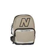 Bandolera tipo mochila pequeña New Balance, color beige con detalles en blanco y negro. Presenta el logo 'N' grande en la parte superior y el nombre de la marca en el bolsillo frontal. Cuenta con dos compartimentos con cierre y correa ajustable.