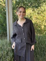 Camisa negra de manga larga con cuello clásico y cierre frontal con botones.