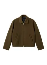 Chaqueta color verde militar, de corte recto con cierre frontal de cremallera, cuello camisero y bolsillos laterales.