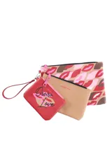 Set de tres necessaires Oreiro de distintos tamaños y colores, elaborados en material sintético. Incluye uno grande con estampado de labios, uno mediano color beige liso y uno pequeño rojo con estampa frontal.