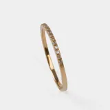 Anillo doble en oro 18k, compuesto por una alianza fina con engaste de brillantes y una alianza lisa con un brillante central.