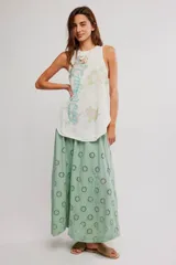 Musculosa blanca de algodón con acabado burnout, diseño sin mangas, espalda nadadora y estampa gráfica frontal con motivos florales y texto.