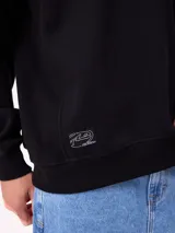 Buzo de cuello redondo Rusty, confeccionado en tejido de algodón y poliéster, con diseño liso en color beige, puños y ruedo acanalados, y detalle de etiqueta de la marca en el frente.