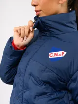 Campera puffer corta de Umbro para el Club Nacional de Football, color azul marino con diseño termosellado. Cuenta con cuello alto, cierre frontal con botones a presión, bolsillos laterales y logo de la marca junto al escudo del club en el pecho.