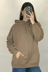 Canguro deportivo de corte oversize, color beige, con capucha ajustable, bolsillo frontal tipo canguro y puños elásticos en mangas y ruedo.
