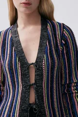 Sacón largo de tejido de punto con rayas verticales en tonos azul, rosa, amarillo y negro. Tiene mangas largas, cuello en V y cierre frontal con lazos.
