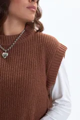 Chaleco de punto color marrón, con cuello alto y diseño sin mangas.