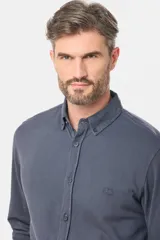 Camisa de manga larga color verde oscuro, con cuello abotonado y logo bordado en el pecho.