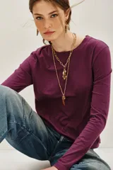Remera de manga larga color ciruela o morado oscuro, con cuello redondo y calce ajustado.