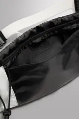 Riñonera deportiva técnica de Zara Athleticz en combinación de colores blanco y negro, con dos compartimentos principales, bolsillos laterales y sistema de sujeción con cordón elástico.