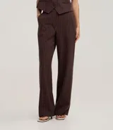 Pantalón de vestir de corte recto, color marrón oscuro con finas rayas verticales en tono más claro. Presenta un calce sastrero y bolsillos laterales.