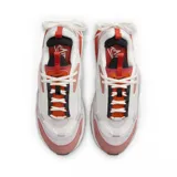 Championes Nike Air Max Furyosa, color gris, blanco y negro, con detalles plateados. Capellada de malla y cuero sintético, con cordones blancos y sistema de ajuste con cordones elásticos en el talón. Entresuela de espuma con tecnología Air Max visible en la parte trasera.