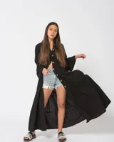 Camisola larga color verde esmeralda con botones de madera, corte holgado, cuello mao y mangas largas acampanadas con volados.