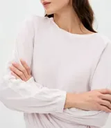 Conjunto de pijama compuesto por blusa de manga larga con cuello redondo y pantalón largo de corte regular. Confeccionado en plush suave, presenta detalles de encaje aplicados en los laterales de las mangas y de las piernas. El pantalón cuenta con cintura elástica para mayor comodidad.